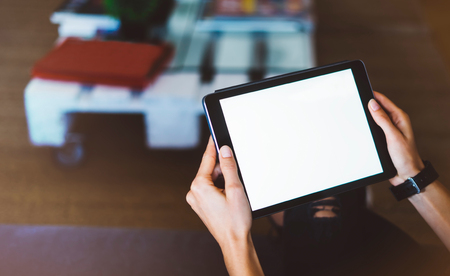 Hipster girl using tablet technology in home, blogger girl person holding computer with blank screen on background bokeh, female hands texting on relax holiday, mockup templates gadget, blur lifestyle conceptの写真素材