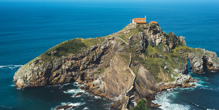 Sea scape on background gaztelugatxe steps sun huan, hipster girl looking on nature horizon ocean, relax holiday, blank space blue waves view, travel trip on Basque country in Spain, popular place of moviesの写真素材