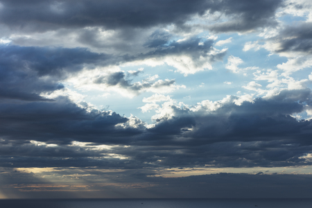 Clouds blue sky and sunlight sunset on horizon ocean. Ð¡loudscape on background seascape dramatic atmosphere rays sunrise. Relax view waves sea, mockup nature evening concept.の写真素材
