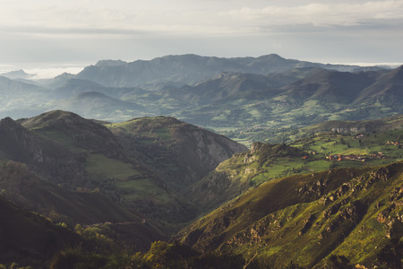 morning mist in the mountain peaks on natural landscape. Green valley on background foggy dramatic sky, mountain tops. Panorama horizon perspective view of scenery hills Northern Spain. Travel mockup conceptの写真素材