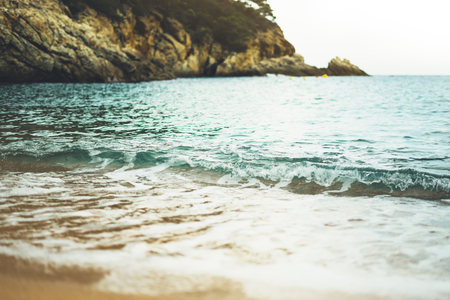 coastline beach on sunny day background of ocean and horizont sky, gold sand close up blur, tourism relax calm concept, seascape perspective vacation, summer seashore on blue sea waves and sand at sunsetの写真素材