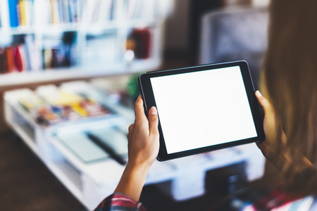 Hipster girl using tablet technology in home, blogger girl person holding computer with blank screen on background bokeh, female hands texting on relax holiday, mockup templates gadget, blur lifestyle conceptの写真素材