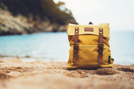Hipster swimming mask on background blue sea ocean horizon, hiker tourist yellow backpack on sand beach, blurred panoramic seascape blank, traveler relax holiday concept, sunlight view in trip vacationの写真素材
