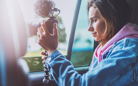 smile tourist girl in an open window of a auto car taking photography click on digital photo camera, photographer looking on camera technology, blogger using hobby content concept, enjoy tripの写真素材