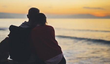 Couple hugging on background beach ocean sunrise, silhouette two romantic people cuddling and looking on rear view evening seascape, hipster with dog enjoy sunset together, travel holidays vacation, love relax conceptの写真素材