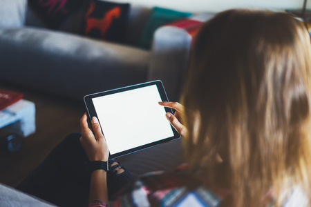 Hipster girl using tablet technology in home atmosphere, girl person holding computer with blank...