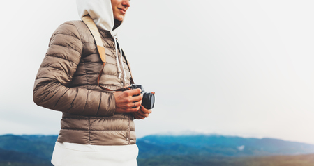 photographer traveler on green top on mountain, tourist looking enjoy nature panoramic landscape in trip, girl holding in hands digital photo camera, hiker taking click photography, relax holiday hobby conceptの写真素材