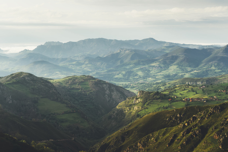 morning mist in the mountain peaks on natural landscape. Green valley on background foggy dramatic sky. Panorama horizon perspective view of scenery hills Northern Spain mountain tops. Travel mockup conceptの写真素材