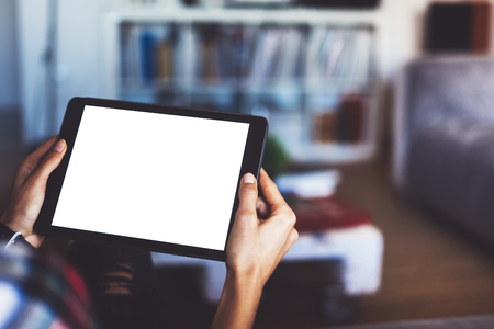 blogger girl person holding computer with blank screen on background bokeh, hipster girl using tablet technology in home, female hands texting on relax holiday, mockup templates gadget, blur lifestyle conceptの写真素材