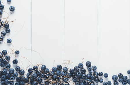 Blueberries on vintage wooden white background top view, healthy food on dark table mockup, berry for smoothie isolated on rustic vintage country board, fresh bilberry nutrition mock up closeup, copy space for text designの写真素材