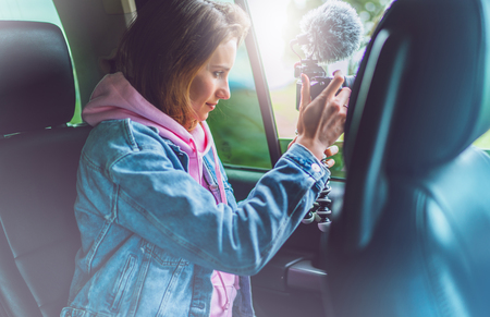 smile tourist girl in an open window of a auto car taking photography click on digital photo camera, photographer looking on camera technology, blogger using hobby content concept, enjoy tripの写真素材