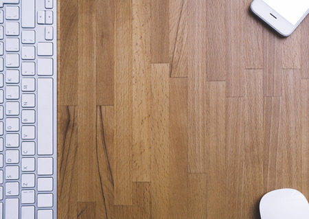 Top view of a keyboard, mouse and smartphone with empty blank screen on a background wooden table, blank for your text or content or design, closeup, free space. Mockup top viewの写真素材