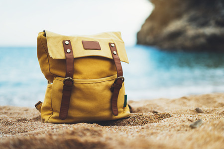 Hipster swimming mask on background blue sea ocean horizon, hiker tourist yellow backpack on sand beach, blurred panoramic seascape blank, traveler relax holiday concept, sunlight view in trip vacationの写真素材