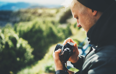 hipster tourist hold in hands taking photography click on retro vintage photo camera in auto,...