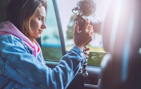 smile tourist girl in an open window of a auto car taking photography click on digital photo camera, photographer looking on camera technology, blogger using hobby content concept, enjoy tripの写真素材