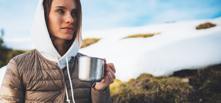 people planning trip in snow mountain, girl hold in hands cup of drinks, relax tourist look on map, hipster enjoy on background winter nature, journey landscape trip, lifestyle holiday conceptの写真素材