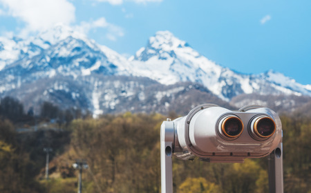 touristic telescope look at the city with view snow mountains, closeup binocular on background viewpoint observe vision, metal coin operated in panorama observation, travel nature conceptの写真素材