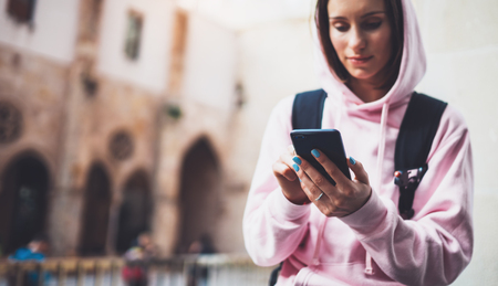 girl hold in hands mobile phone, person type message on smartphone, relax tourist travels planning trip in city, hipster enjoy journey in cityscape, lifestyle holiday concept, internet onlineの写真素材