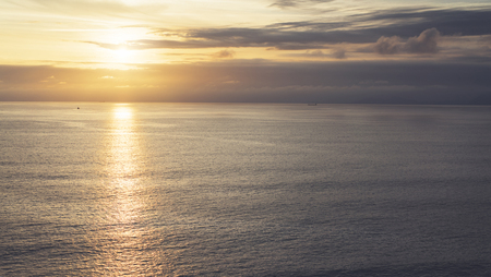 Clouds sky and sunlight sunset on horizon ocean. Silhouette person on background seascape dramatic atmosphere rays sunrise. Relax view waves water sea, mockup nature evening concept perspective sunriseの写真素材