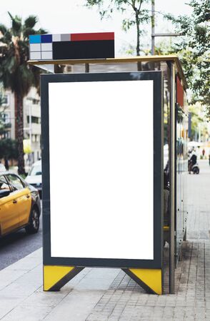 Blank advertising light box on bus stop, mockup of empty ad billboard on night bus station, template banner on background city street for message or text in Barcelona, afisha board and headlights of taxi carsの写真素材