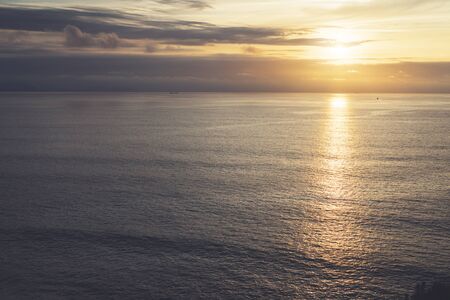 Clouds sky and sunlight sunset on horizon ocean. Silhouette person on background seascape dramatic atmosphere rays sunrise. Relax view waves water sea, mockup nature evening concept perspective sunriseの写真素材