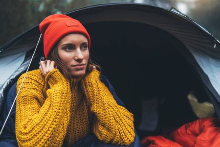 tourist traveler ralaxing in camp tent in froggy mist forest, portrait lonely hiker woman enjoy nature trip, green trekking tourism, rest vacation concept camping holidayの写真素材