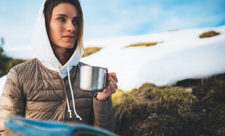 people planning trip in snow mountain, girl hold in hands cup of drinks, relax tourist look on map, hipster enjoy on background winter nature, journey landscape trip, lifestyle holiday conceptの写真素材