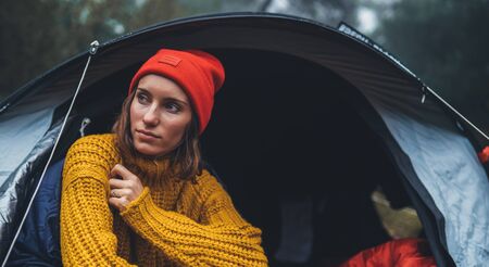 tourist traveler ralaxing in camp tent in froggy rain forest, closeup lonely hiker woman enjoy mist nature trip, green trekking tourism, rest vacation concept camping holiday, copy spaceの写真素材