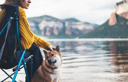 tourist traveler girl relax together friends dog on background mountain landscape,  woman hugging pet rest on lake shore nature tripの写真素材