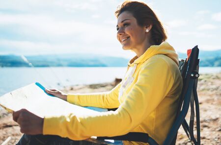 traveler girl hold in hands map and look landscape vacation trip, smile people planning trip, hipster tourist relax on nature, enjoy lifestyle holiday conceptの写真素材