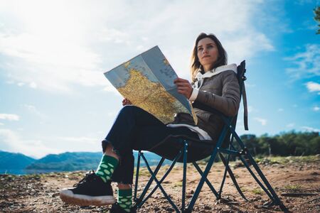 traveler girl hold in hands map and look landscape vacation trip, hipster planning trip, tourist on nature, enjoy lifestyle holiday concept, mountainの写真素材