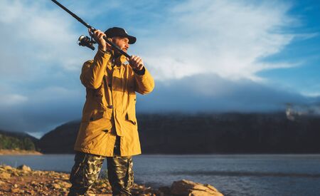 fishery concept, beard fisherman hold fishing rod, man enjoy hobby sport on evening lake, person...