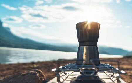 hot coffee campsite morning lifestyle, person cooking drink in nature camping outdoor, cooker prepare breakfast picnic, tourism recreation outsideの写真素材