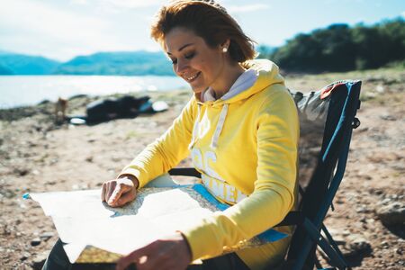 traveler girl looking on map vacation trip, woman planning trip, hipster tourist on background nature, enjoy lifestyle holiday conceptの写真素材