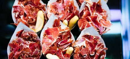 slice spanish hamon in barcelona market, jamon iberico isolated, traditional national spain meat in store, serrano prosciutto food on background gastronomy, bacon berian on cuisineの写真素材