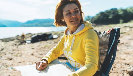 traveler girl looking on map, vacation trip, people planning trip, hipster tourist on background sun flare nature, enjoy lifestyle holiday conceptの写真素材