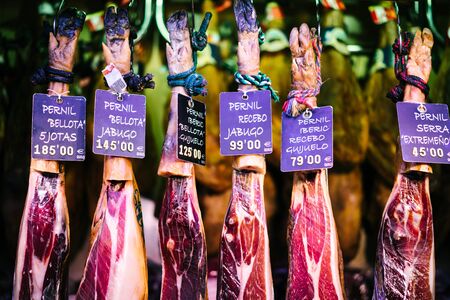 Spanish hamon in barcelona market, jamon iberico in view black leg pork isolated, traditional national spain meat in store, serrano prosciutto food on background gastronomyの写真素材
