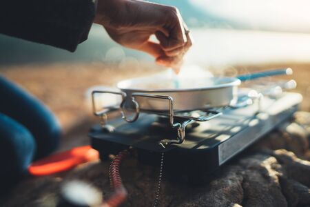 person cooking in nature camping outdoor, cooker prepare breakfast,  picnic on metal gas stove, campsite lifestyleの写真素材
