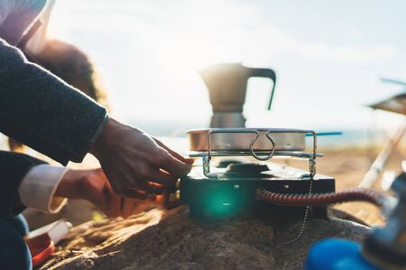 moka pot coffee outdoor, campsite morning picnic lifestyle, person cooking hot drink and food in nature camping, cooker prepare breakfastの写真素材