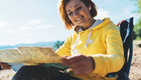 traveler girl smiling and looking on map vacation trip, woman planning trip, hipster tourist enjoy lifestyle holiday conceptの写真素材