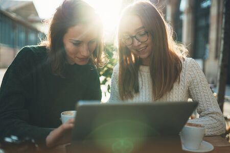 Freelancer designer communicate on project, Friends shopping online, smile students studies on internet, girls working on computer in cafe outdoorの写真素材