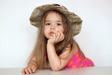 Cute happy baby girl wearing swimming suit, sun glasses and hat over white background, summer vacation conceptの写真素材