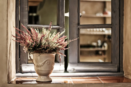 Old wooden window with lavender in the ceramic pot, tinted image, close-up objectの写真素材
