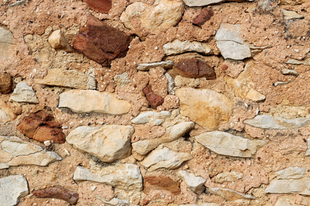 Pattern brown color of uneven cracked real stone wall surface, background, from Provence, Franceの写真素材