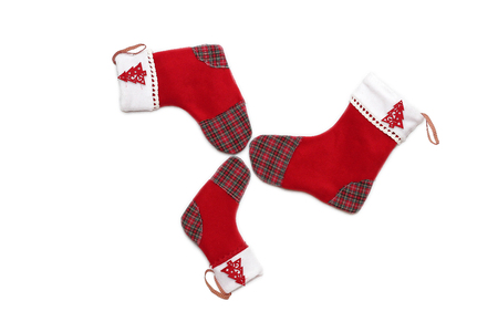 Three red Christmas socks with tree decor for Santa gifts arranged circle-wise on white background, winter holidays symbolの写真素材