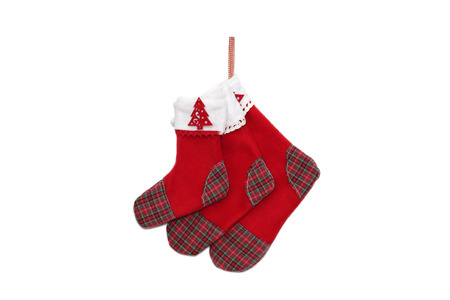 Three red Christmas socks with tree decor for Santa gifts on white background, winter holidays symbolの写真素材