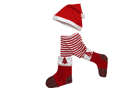 Christmas clothes and attributes forming a little walking child on white background, winter holiday symbolの写真素材