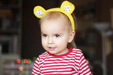Close-up portrait of happy toddler boy with teddy bear ears looking inspired, human emotionsの写真素材