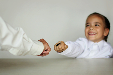A cute little girl and her grandmother showing their fists with felt moustaches rings, happy father day and men health conceptの写真素材