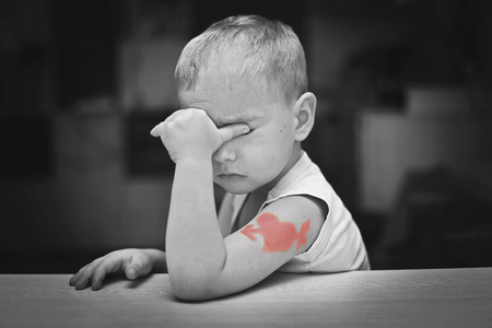 Little boy in soft pink bow-tie and with heart symbol tattoo thinking thoughtfully, he falls in love, romantic and love concept, Valentine Day greetingの写真素材